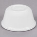 A Carlisle white melamine ramekin on a gray surface.