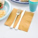 A plate of food and a fork on a napkin.