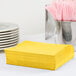 A stack of yellow Creative Converting luncheon napkins.