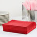 A stack of Classic Red luncheon napkins on a table.