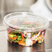 A Choice plastic container of salad on a counter.