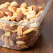 A 16 oz. Square recycled PET deli container filled with mixed nuts.