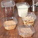 Square plastic deli containers holding nuts, chocolate chips, and other food.