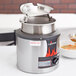 A Vollrath Cayenne 4 quart soup warmer with a hinged lid on a pot of soup.