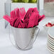 A bucket of pink plastic forks.