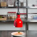 A red lamp from the ceiling warming a plate of food.