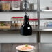 A black lamp with infrared bulbs hanging over a plate of food.