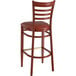 A Lancaster Table & Seating Spartan Series bar stool with a mahogany wood grain finish and burgundy vinyl cushion.