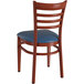 A Lancaster Table & Seating metal ladder back chair with mahogany wood grain finish and navy vinyl seat.