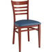 A Lancaster Table & Seating metal ladder back chair with mahogany wood grain finish and navy vinyl cushion.