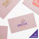 A group of pink packets of Choice custom pink paper napkins with white and gold text.