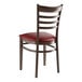 A Lancaster Table & Seating metal ladder back chair with dark walnut wood grain finish and burgundy vinyl seat.