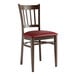 A Lancaster Table & Seating metal slat back chair with dark walnut wood grain finish and burgundy vinyl seat.