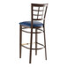 A Lancaster Table & Seating metal bar stool with a navy vinyl seat.