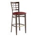 A Lancaster Table & Seating Spartan Series bar stool with dark walnut wood grain finish and a burgundy vinyl seat.