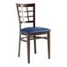 A Lancaster Table & Seating Spartan Series chair with a navy blue cushion and wood grain window back.