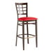 A Lancaster Table & Seating Spartan Series bar stool with a red vinyl seat and dark walnut wood grain finish.