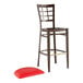 A Lancaster Table & Seating Spartan Series metal bar stool with a red vinyl seat.