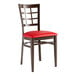 A Lancaster Table & Seating Spartan Series restaurant chair with a dark walnut wood frame, and red vinyl seat.