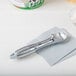 A Vollrath silver aluminum ice cream scoop on a white surface.