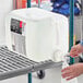 A person pouring 3M Sharpshooter No-Rinse Mark Remover into a plastic jug.