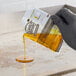 A packet of 3M Scotch-Brite liquid griddle quick clean being poured onto a griddle surface.