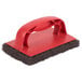 A red and black 3M Scotch-Brite sponge with a red handle.