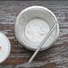 A bowl of white liquid and a stainless steel American Metalcraft mini whisk.