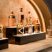 A two-tiered liquor display with built-in LED lighting, showcasing various bottles of liquor on a countertop.