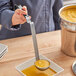 A person using a Vollrath Jacob's Pride ladle to serve soup