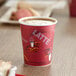 A red Solo Bistro print paper hot cup with a brown liquid in it.