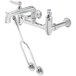 A close-up of a chrome T&S service sink faucet with a handle and hose.