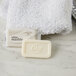 A white bar of Dial White Marble Deodorant Soap on a marble counter next to a white towel.