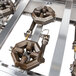 A metal Cooking Performance Group front main burner pipe assembly with holes.