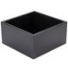 A black Cal-Mil cube riser on a table.