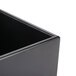 A black Cal-Mil cube riser on a table.
