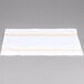 A white surface with a gold and white striped Snap Drape cloth napkin.