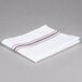A folded white napkin with brown stripes.