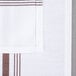 A white cloth napkin with a brown stripe down the middle.