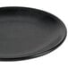 A close up of a Hall China Foundry black coupe plate.