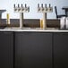 A Beverage-Air black beer dispenser with four taps on a counter.