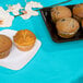 A plate of muffins on a blue table with a Bermuda Blue table cover.