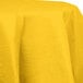 A yellow Creative Converting School Bus Yellow OctyRound tablecloth on a white table.