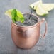 A Libbey copper Moscow Mule mug with ice and mint leaves.