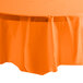 A Sunkissed Orange Creative Converting plastic table cover on a table.