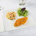 A Libbey square white porcelain plate with fried chicken and rice on it.