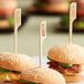 Three burgers with Tablecraft allergy picks on a plate.