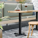 A FLAT Tech black table base with a glass of wine on a table.
