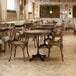 A FLAT Tech black dining height table base in a room with tables and chairs.