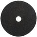 A 3M black circular stripping floor pad with a hole in the middle.